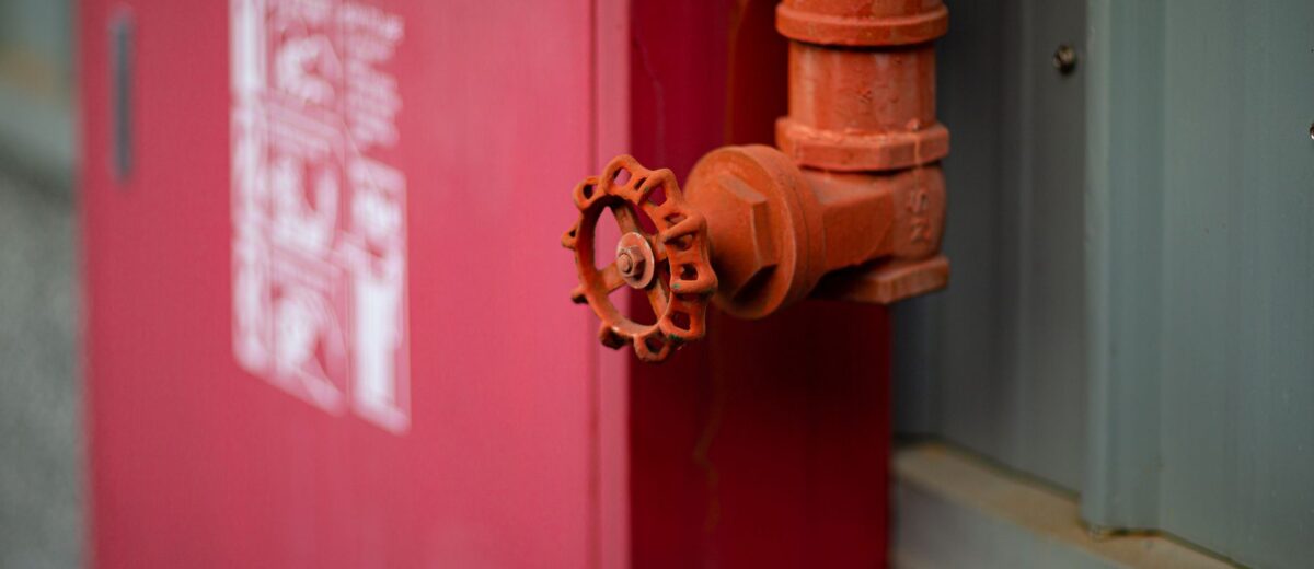 Detailed view of a red fire hydrant with valve in an urban setting in Taiwan.