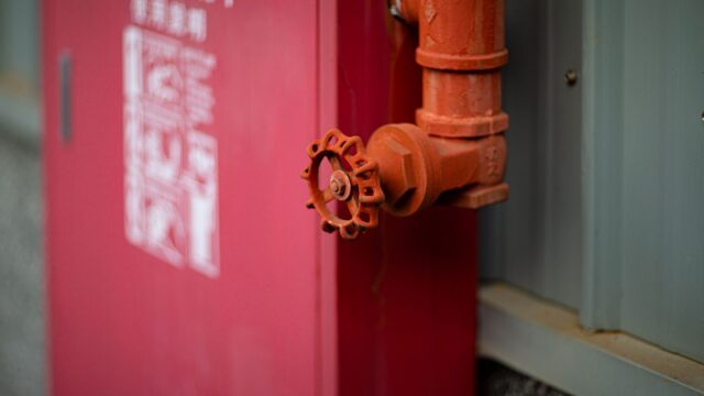 Detailed view of a red fire hydrant with valve in an urban setting in Taiwan.